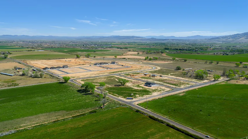 Expansive development site featuring multiple building pads, established roads, and surrounding green fields