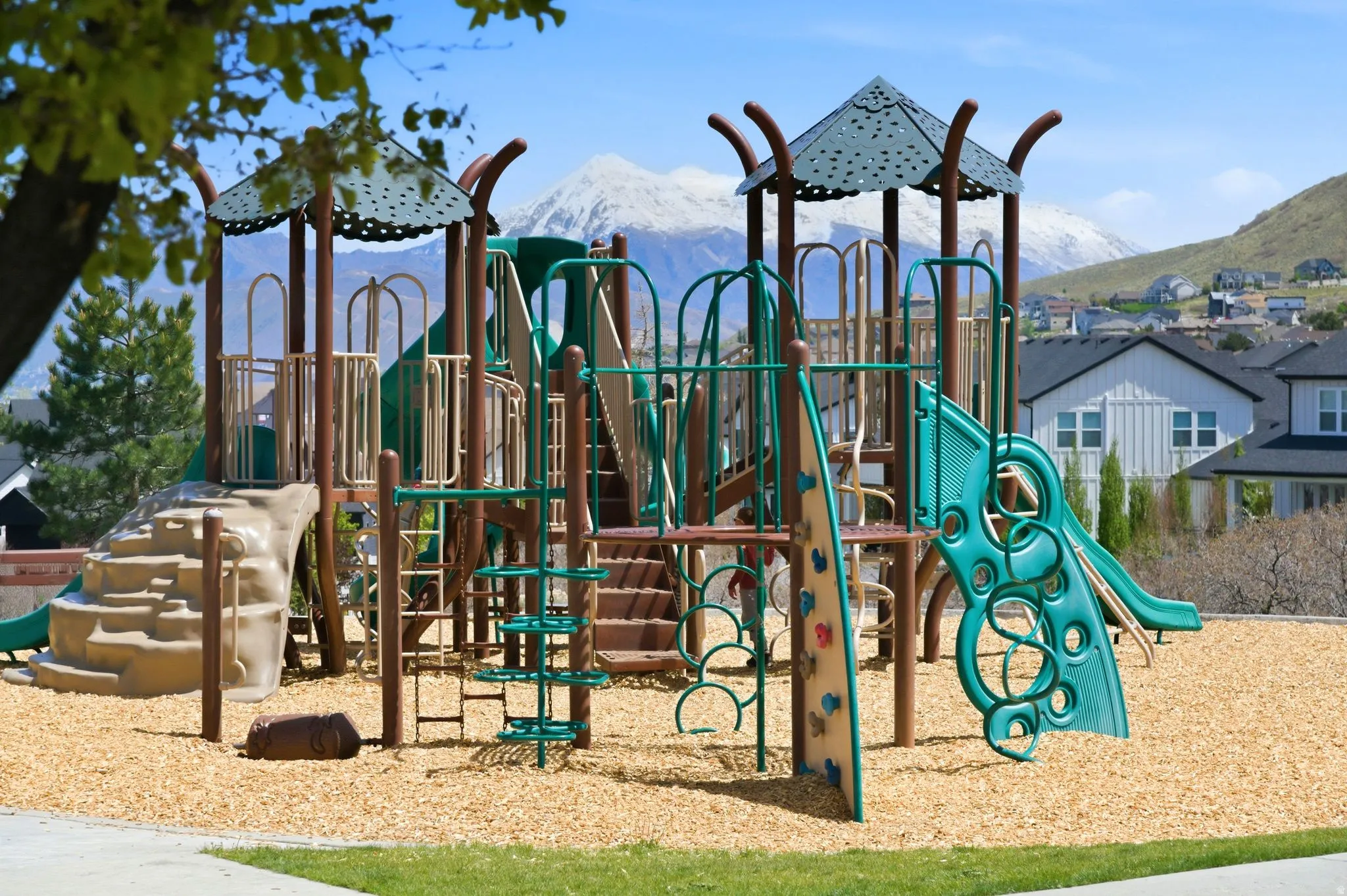 Community playground featuring multiple slides, climbing structures, and a wood chip surface