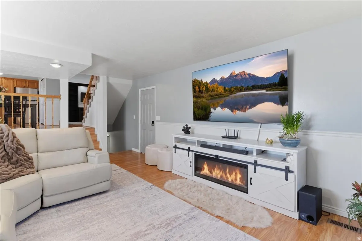 Bright living space featuring wood-finish flooring, light grey painted walls, and white baseboards
