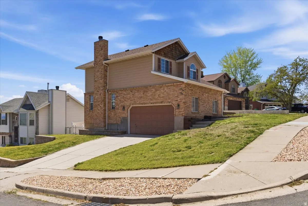 Brick and siding exterior with an attached garage and a prominent chimney