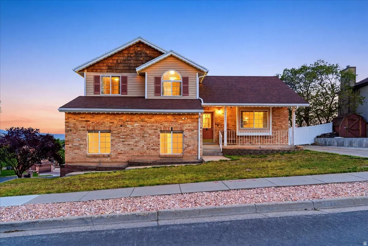 Traditional two-story residence featuring a brick facade and vinyl siding