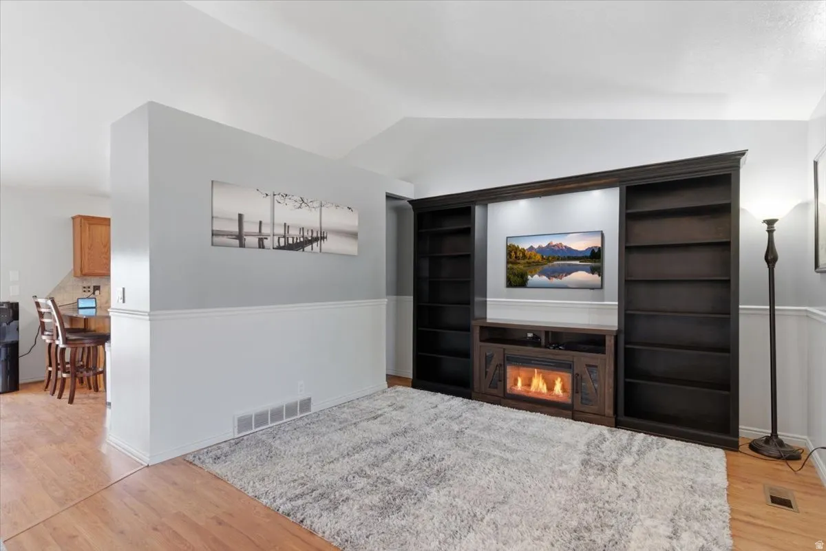 Integrated entertainment center featuring built-in shelving, a recessed media area, and an electric fireplace