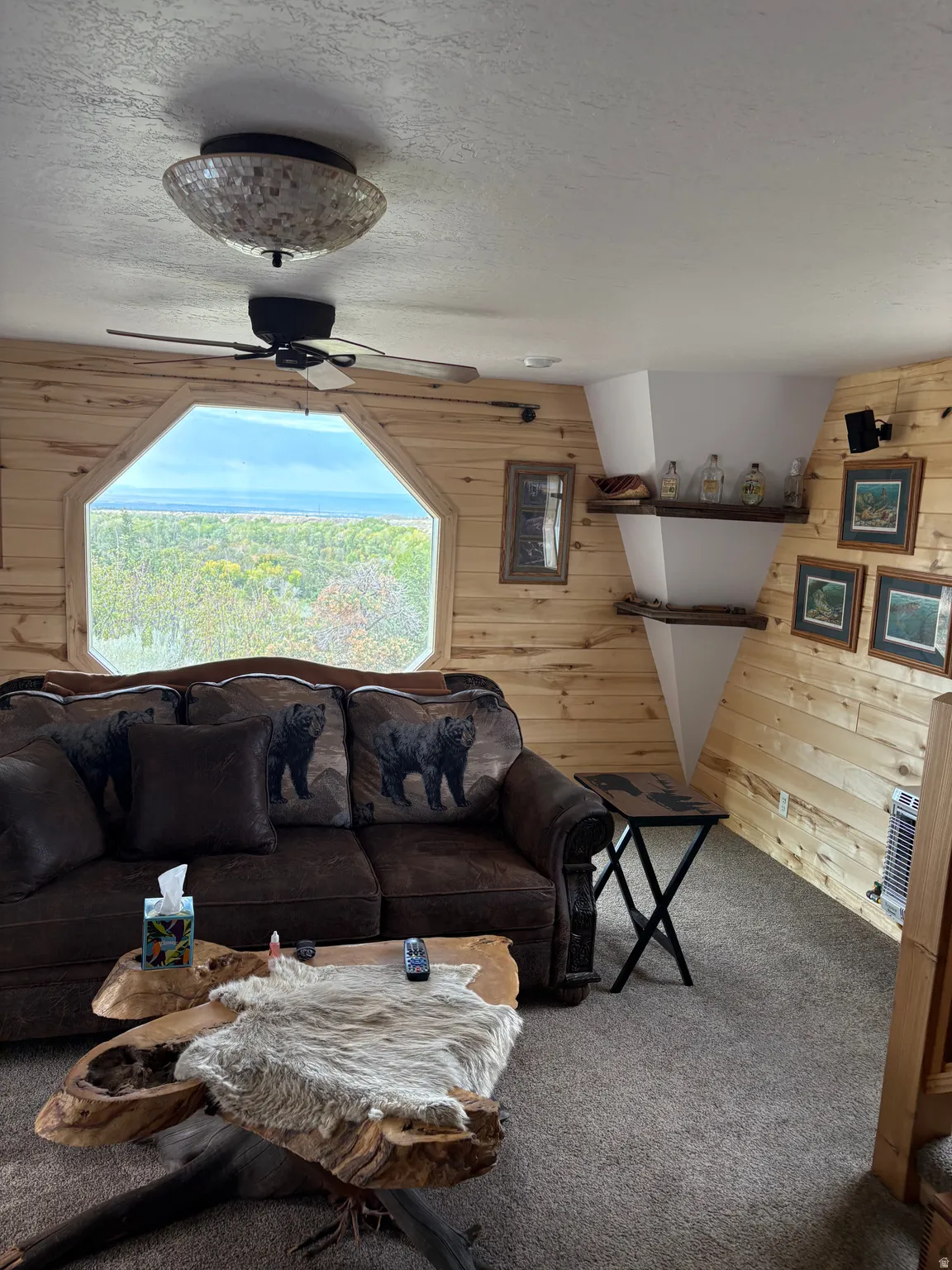 Wood-paneled room featuring an octagonal window with an expansive exterior landscape