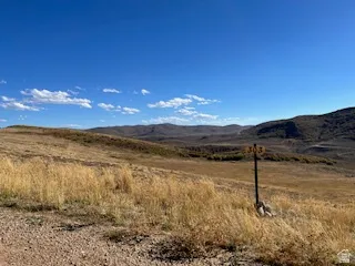 Expansive undeveloped land featuring natural terrain and distant mountains under a clear sky
