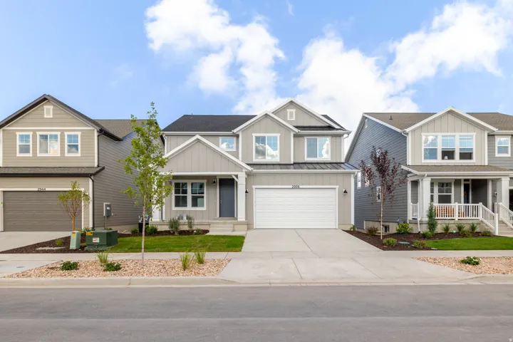 Two-story property with light gray siding, white trim, and a prominent front-facing garage