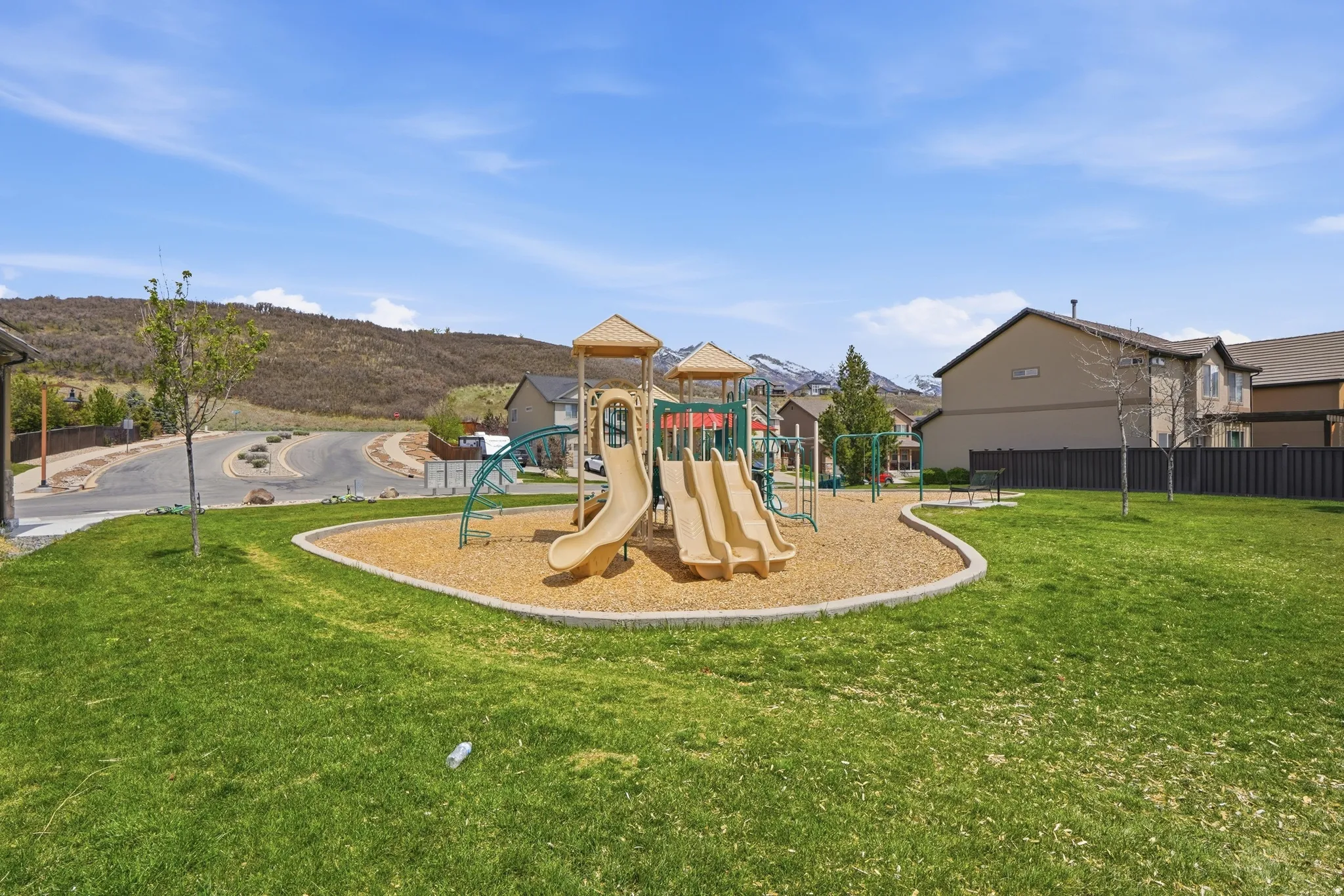 Community playground featuring a multi-level play structure with slides and swings