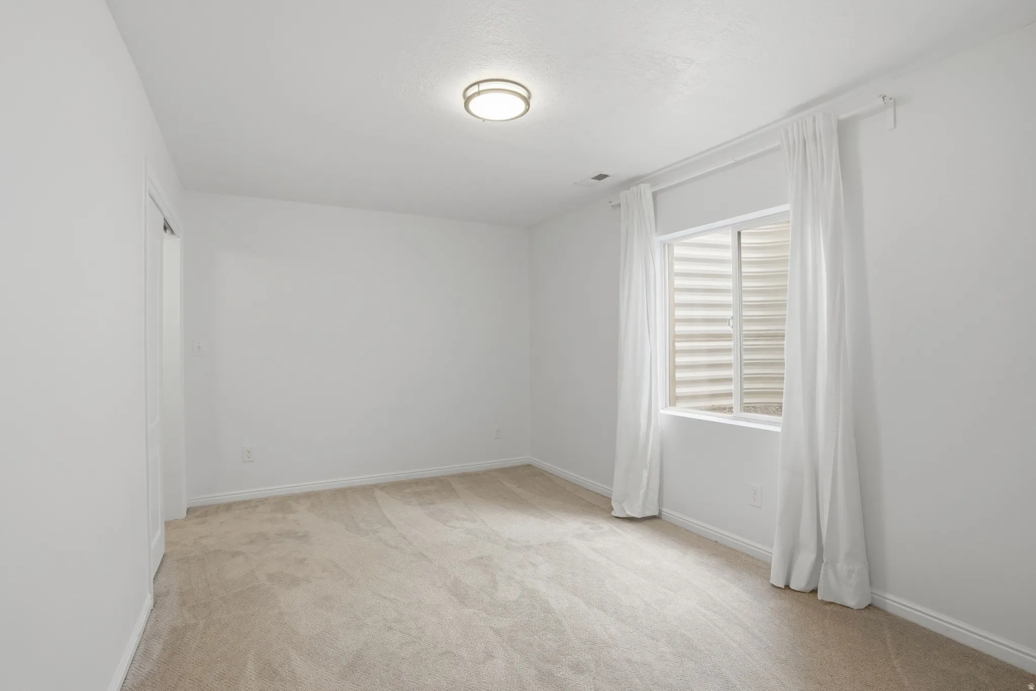 Neutral-toned carpeting paired with white baseboards and walls