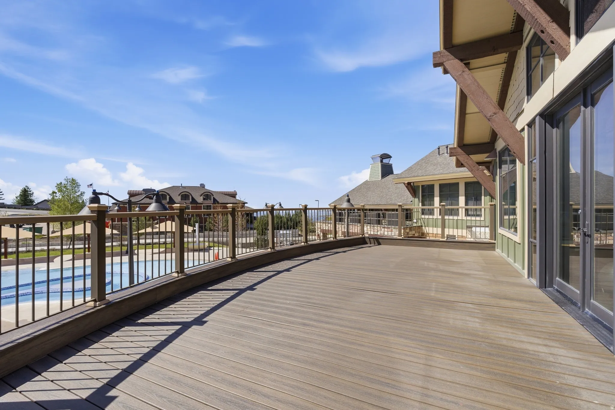 Expansive outdoor deck featuring wood-finish flooring and a black metal railing