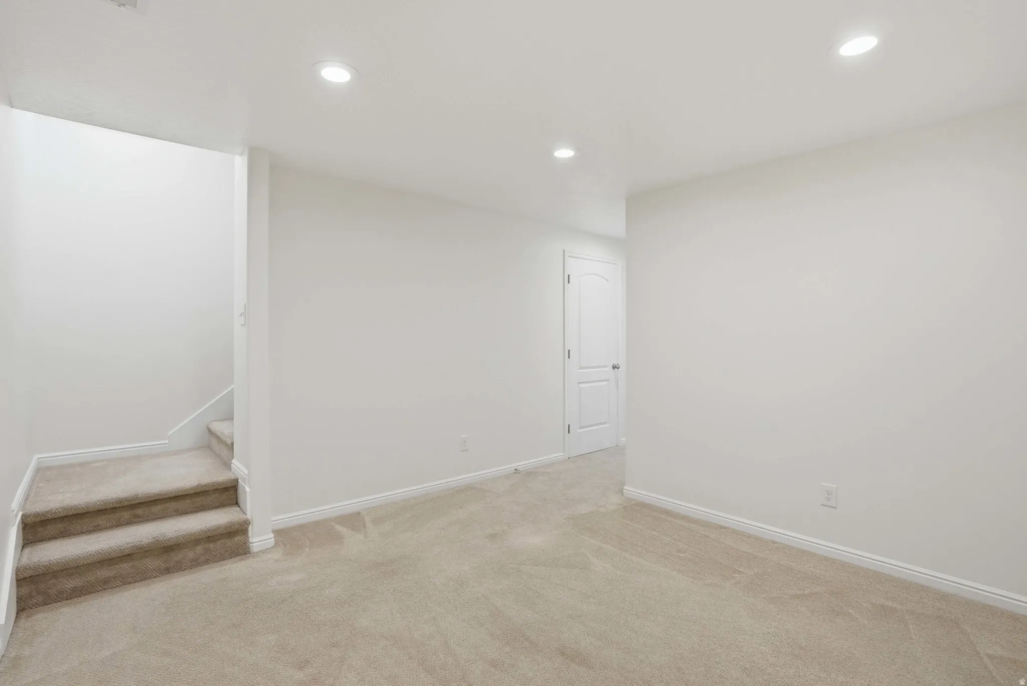 Carpeted room with recessed lighting and a neutral color palette