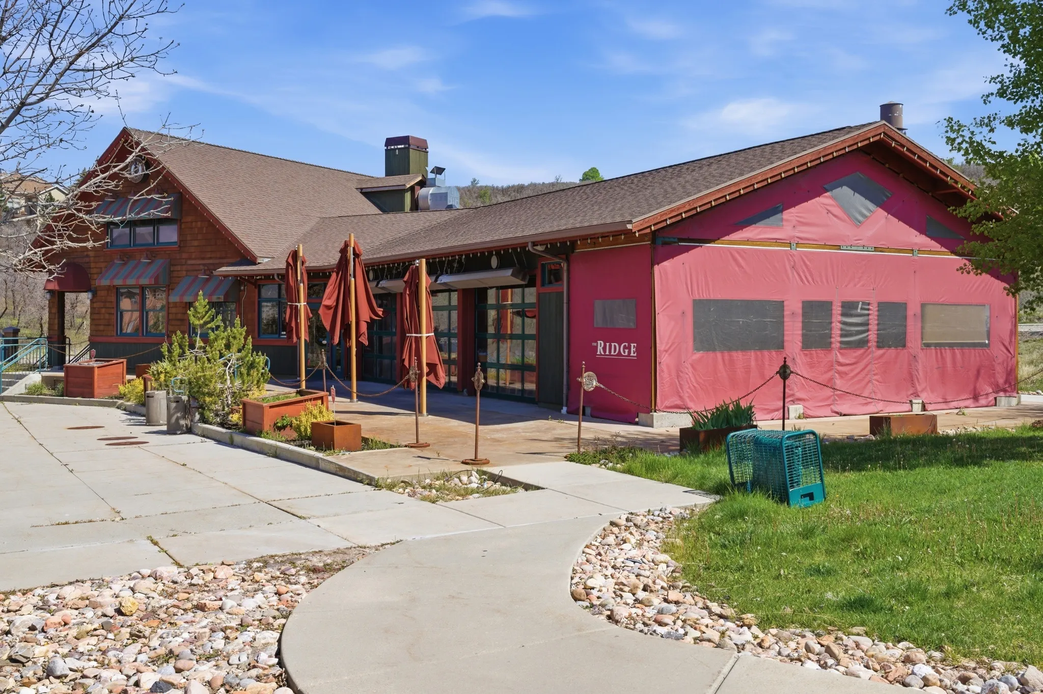 Property exterior featuring natural wood siding and a brown shingle roof