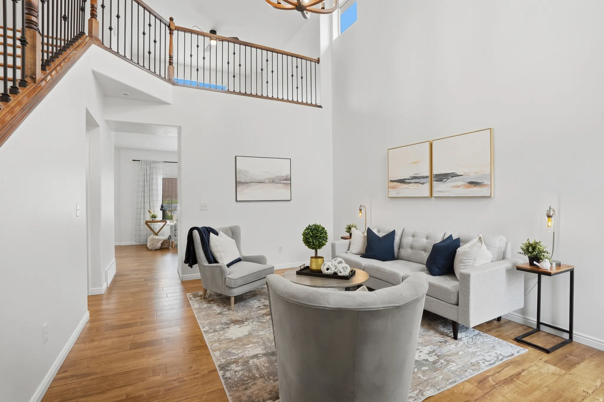 Vaulted ceilings define this inviting living space, featuring wood-finish flooring throughout the main level