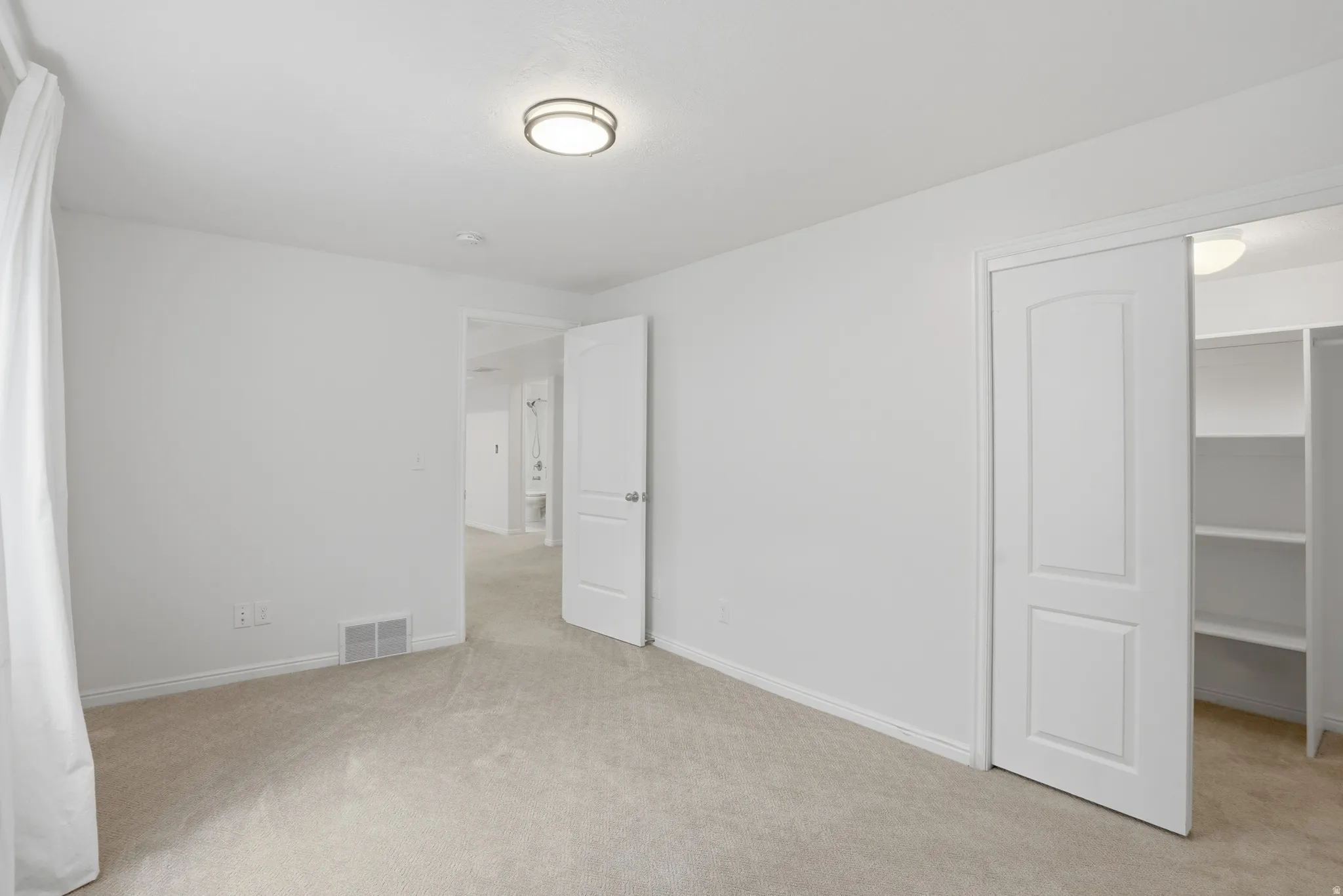 Neutral tone carpeting complements the white walls and trim