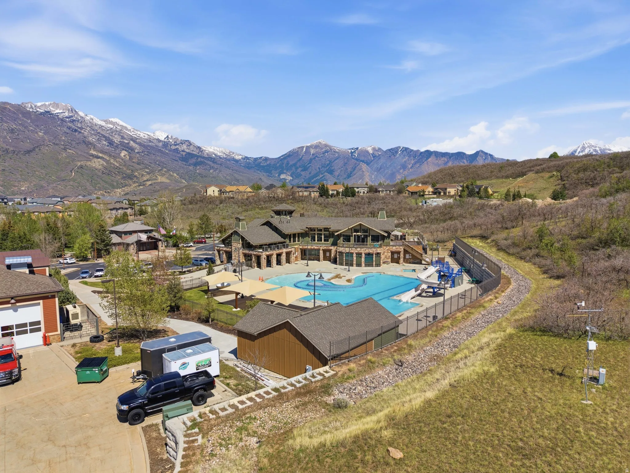 Community amenities featuring a large swimming pool, water slides, and shade structures