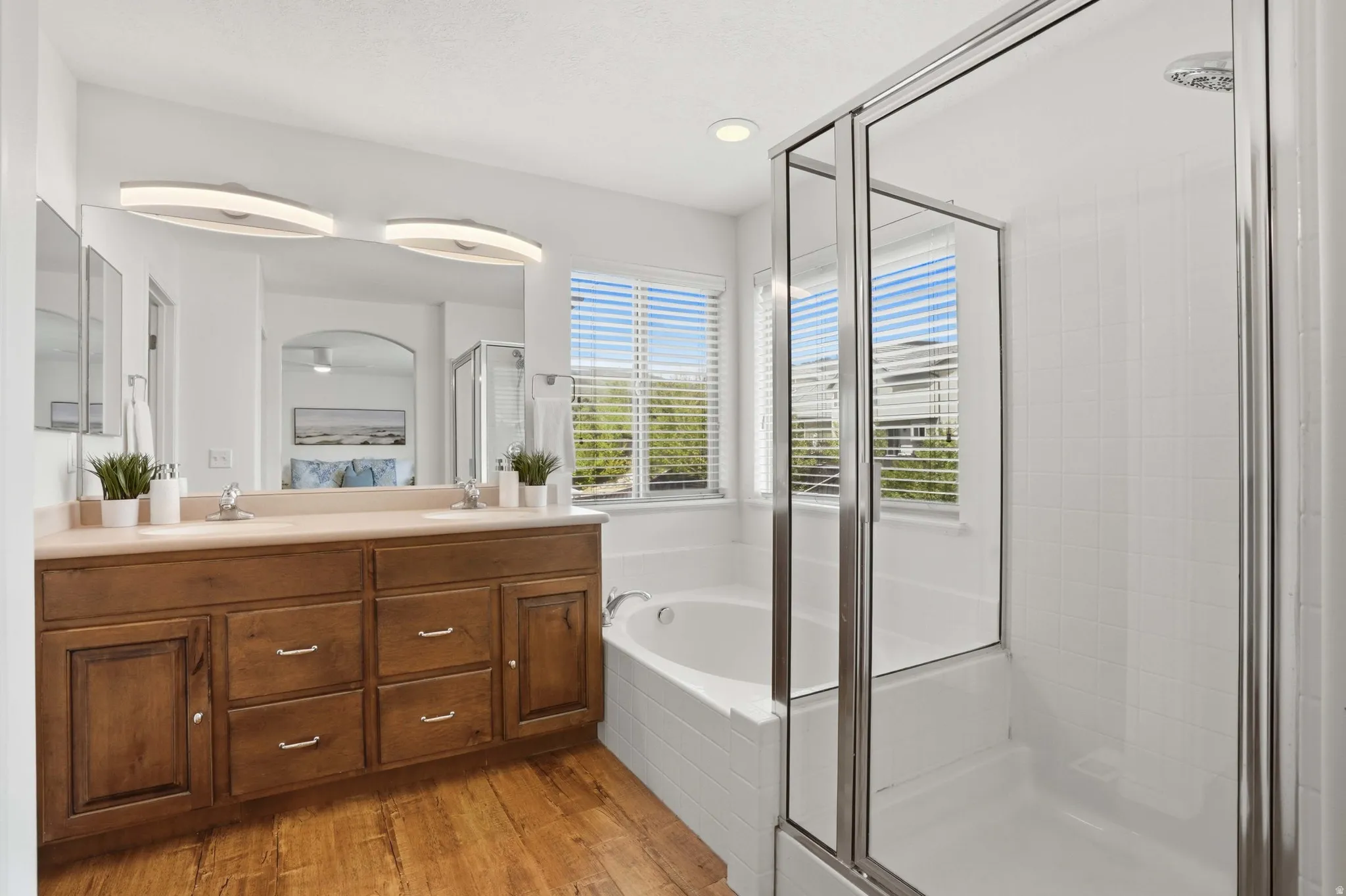 Bathroom featuring a double vanity with wood-finish cabinetry and a light-toned countertop