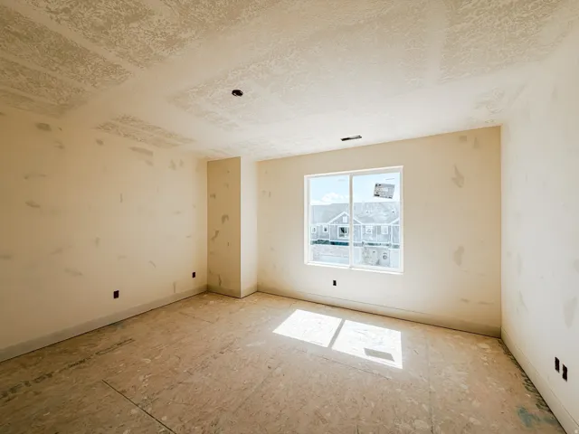 Spacious interior with an exposed subfloor and a large window