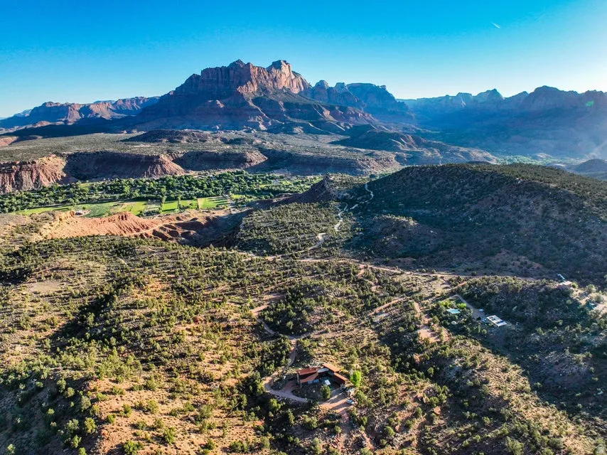Expansive aerial view showcasing a residence set within a mountainous desert landscape
