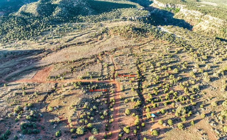 Expansive undeveloped land featuring diverse terrain, natural scrub brush, and established trees