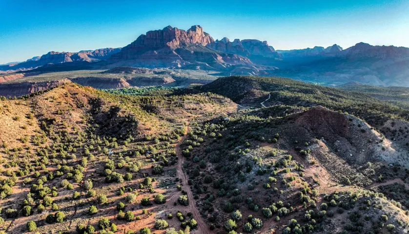 Expansive desert landscape featuring rugged terrain and distant mountain ranges