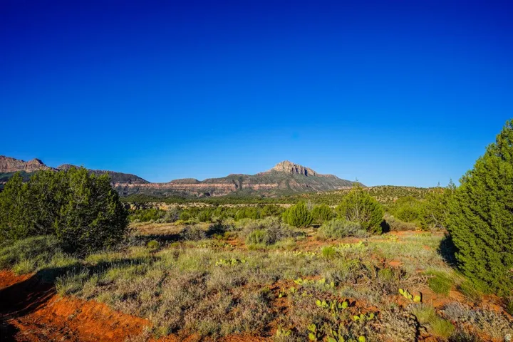 Expansive desert landscape featuring distant mountains and a clear, wide-open sky