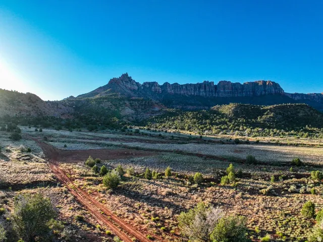 Expansive desert landscape featuring rugged mountain formations under a clear sky