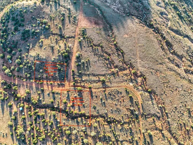 Expansive aerial view of undeveloped land featuring varied topography, natural vegetation, and unpaved access paths