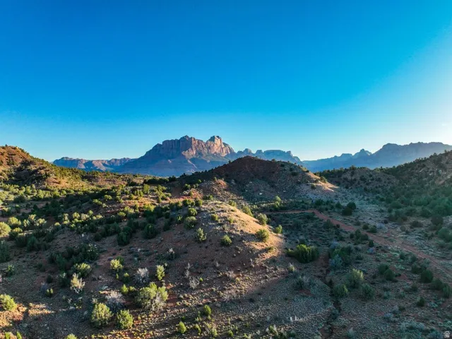 Expansive desert landscape featuring rolling hills and distant mountain formations
