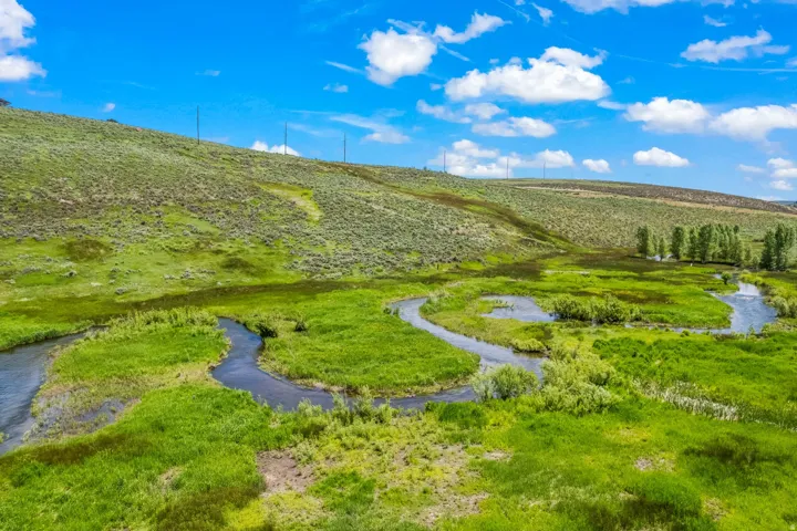 Natural landscape with a winding river, verdant grasslands, and distant hills