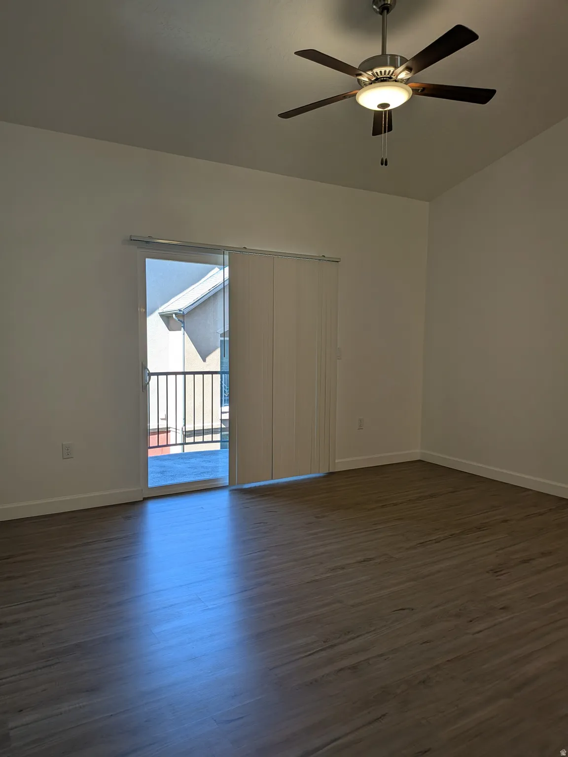 Unfurnished room featuring dark wood finished floors and a ceiling fan