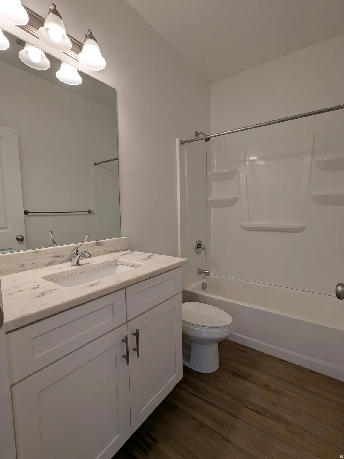 Bathroom featuring vanity, shower / bathtub combination, and dark wood-style floors