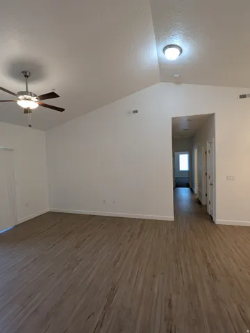 Spare room with dark wood-style flooring and ceiling fan