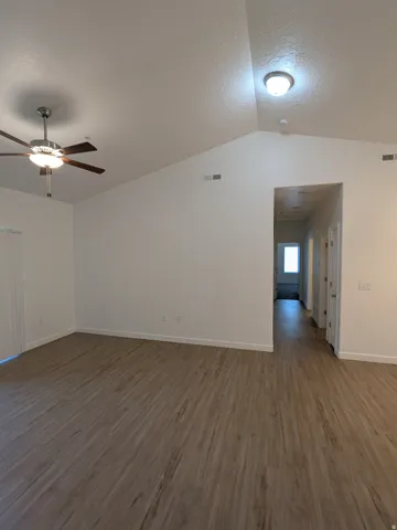 Empty room featuring dark wood-style floors and ceiling fan