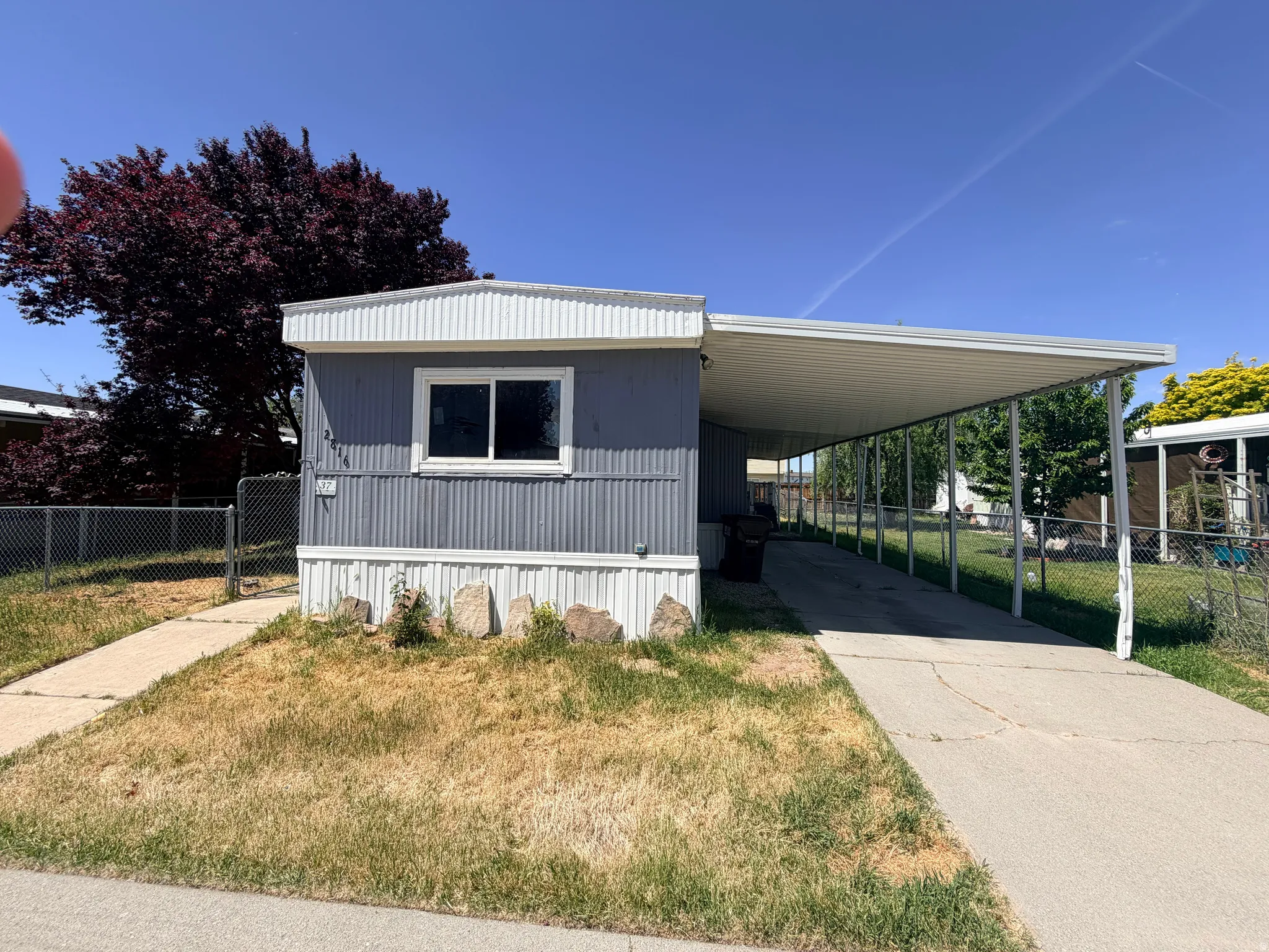 Manufactured home featuring horizontal siding, white trim, and a covered carport