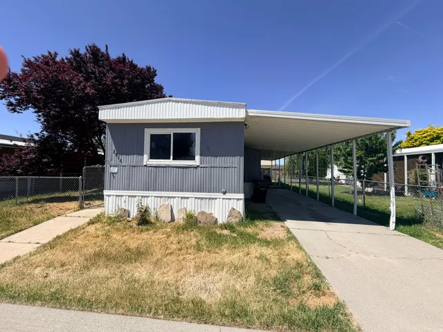Manufactured home featuring horizontal siding, white trim, and a covered carport