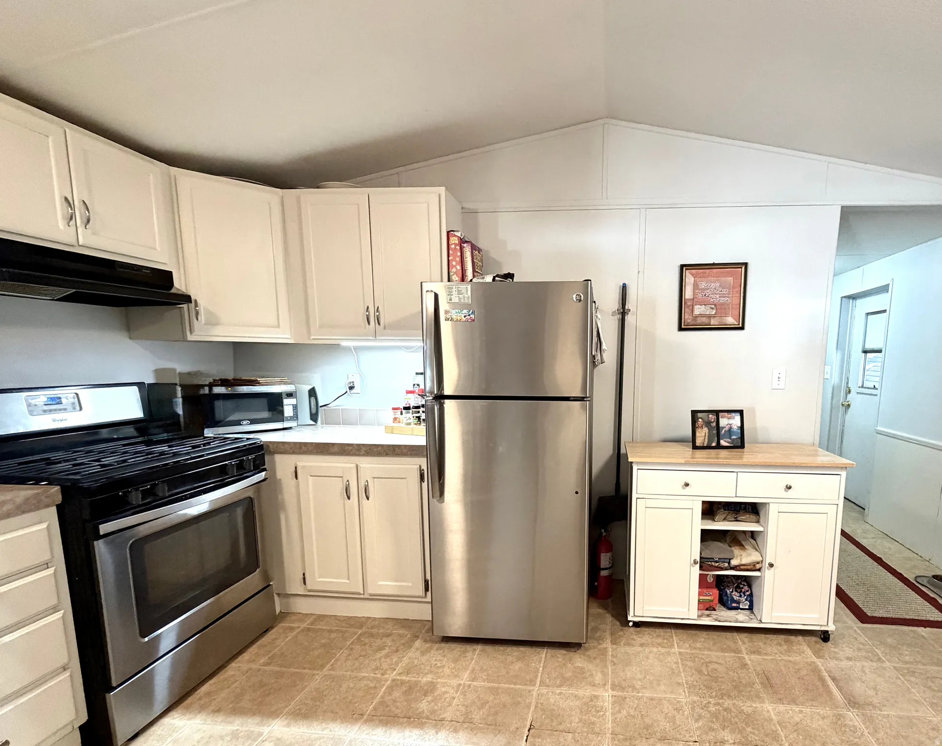Large, open kitchen featuring peninsula with countertop seating, plenty of counter and cabinet space, stainless appliances, large pantry