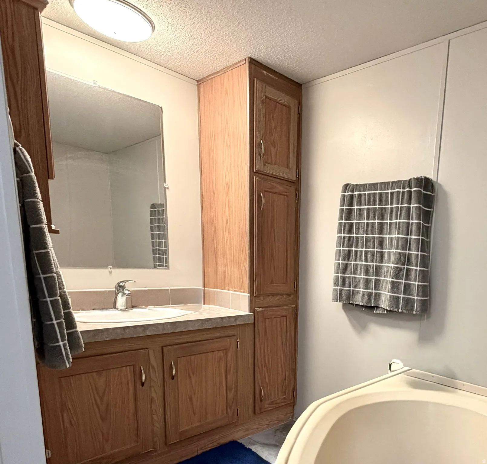 Large primary bathroom with plenty of cabinet storage, soaker tub, and separate shower