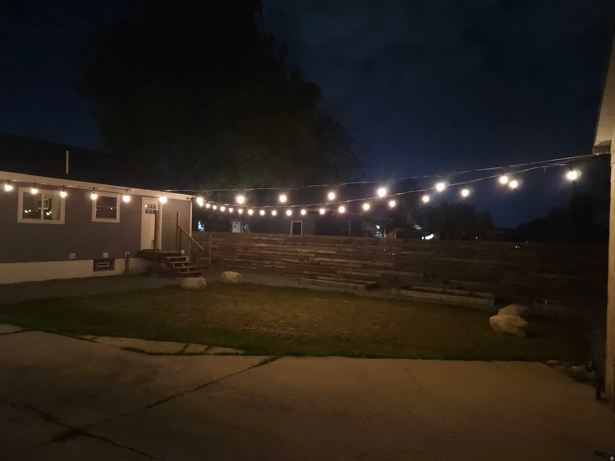 Exterior concrete patio with string lighting illumination