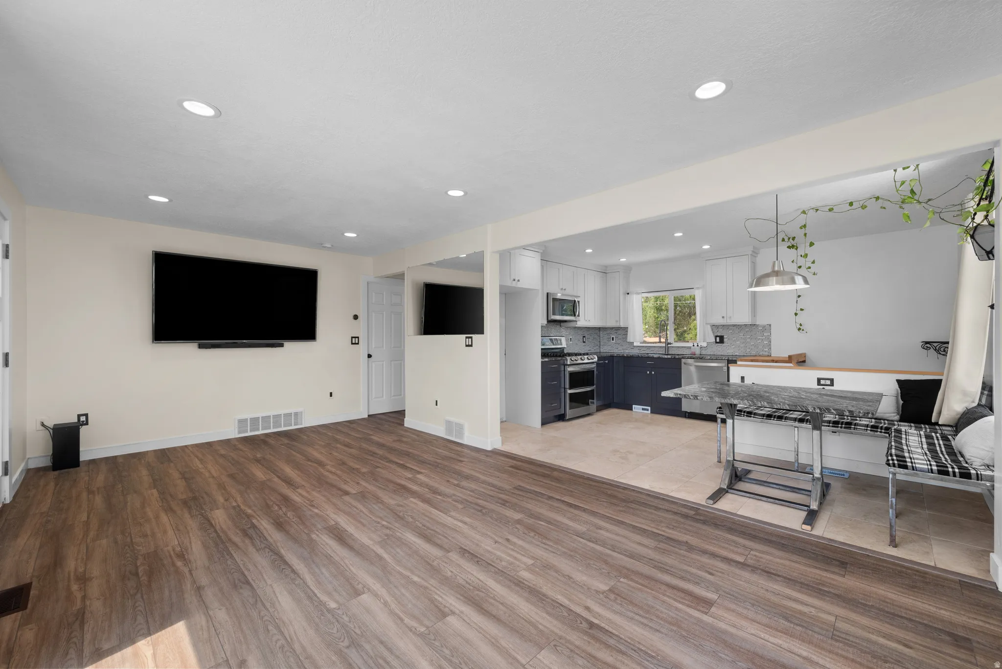 Spacious open-concept living area featuring wood-finish flooring and recessed lighting