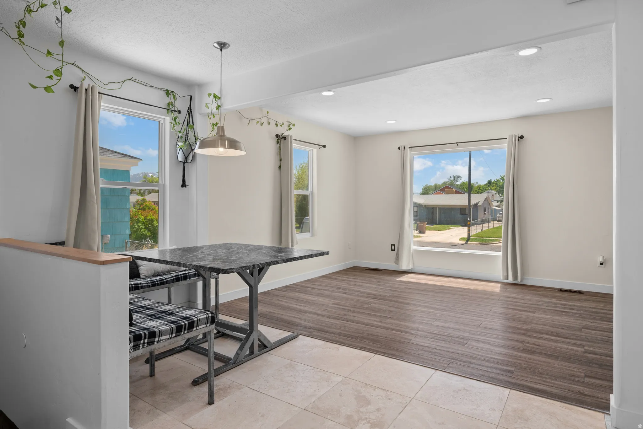 Open-concept living area featuring a wood-finish floor, recessed lighting, and large windows