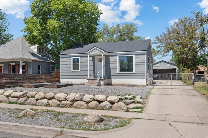 Gray siding exterior with white trim, dark shingle roof, and a front porch