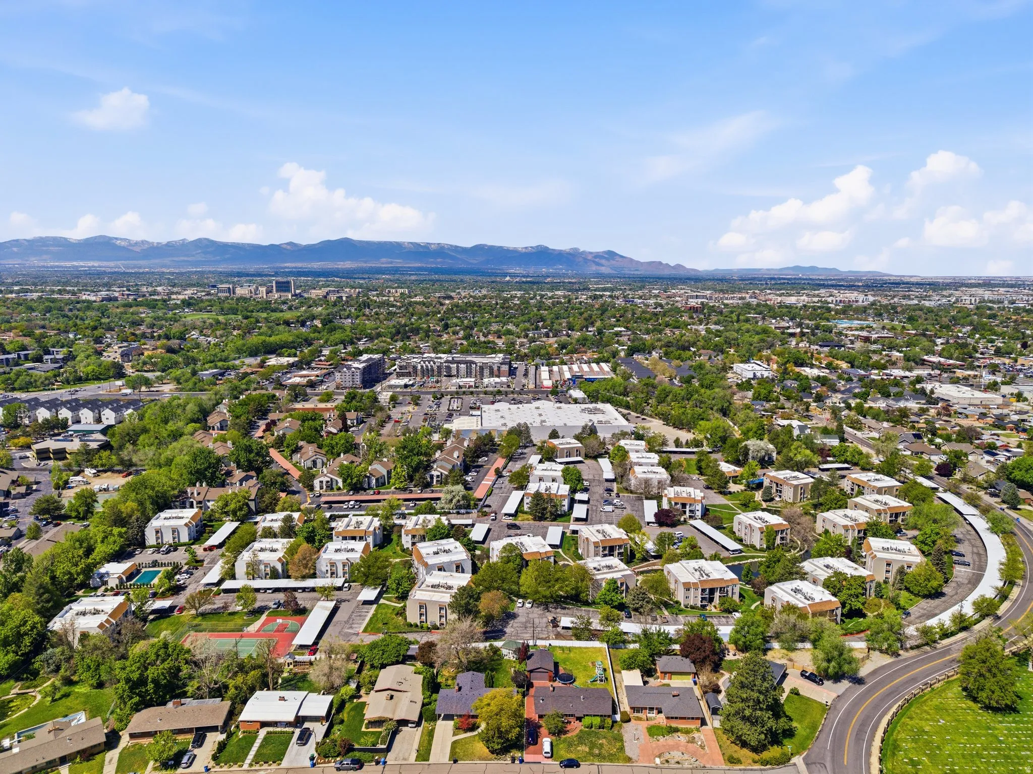 Expansive aerial view showcasing a residential neighborhood with a mix of single-family homes and multi-story apartment buildings