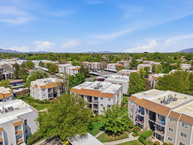 Aerial perspective showcasing a complex of multi-story residential buildings with pitched shingle roofs and private balconies