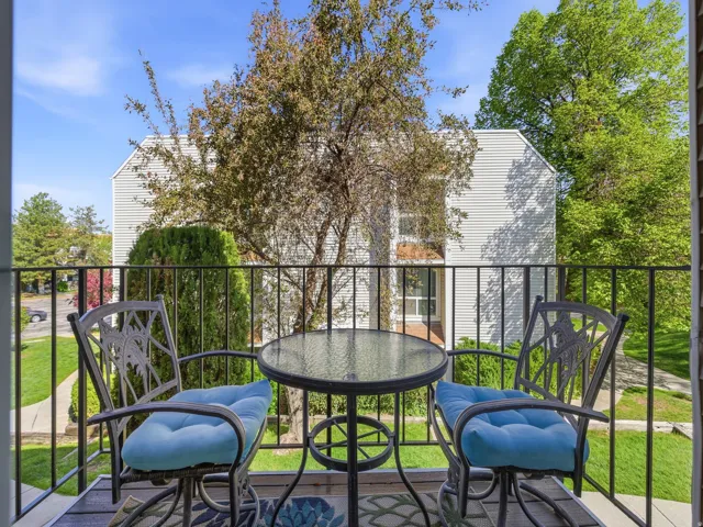 Outdoor balcony featuring a black metal railing and wood-finish flooring