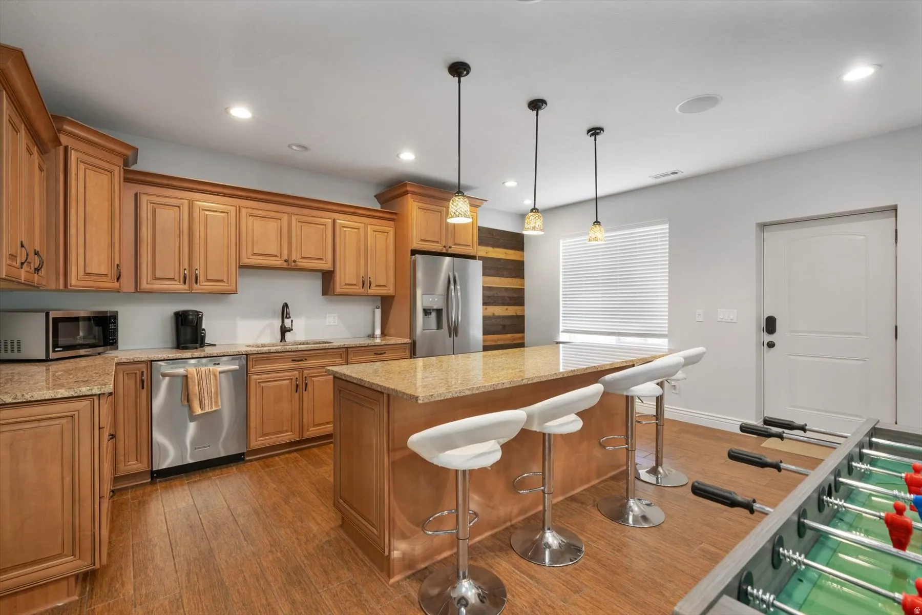 Basement Kitchen featuring wood-finish cabinetry, granite-style countertops, and stainless steel appliances