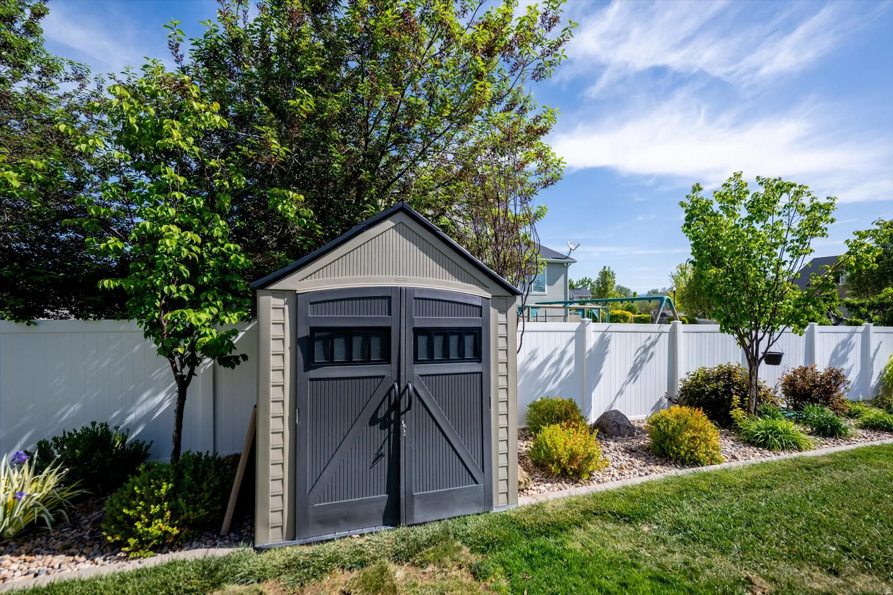 Outdoor storage shed featuring a dual-tone exterior, double doors, and a gable roof