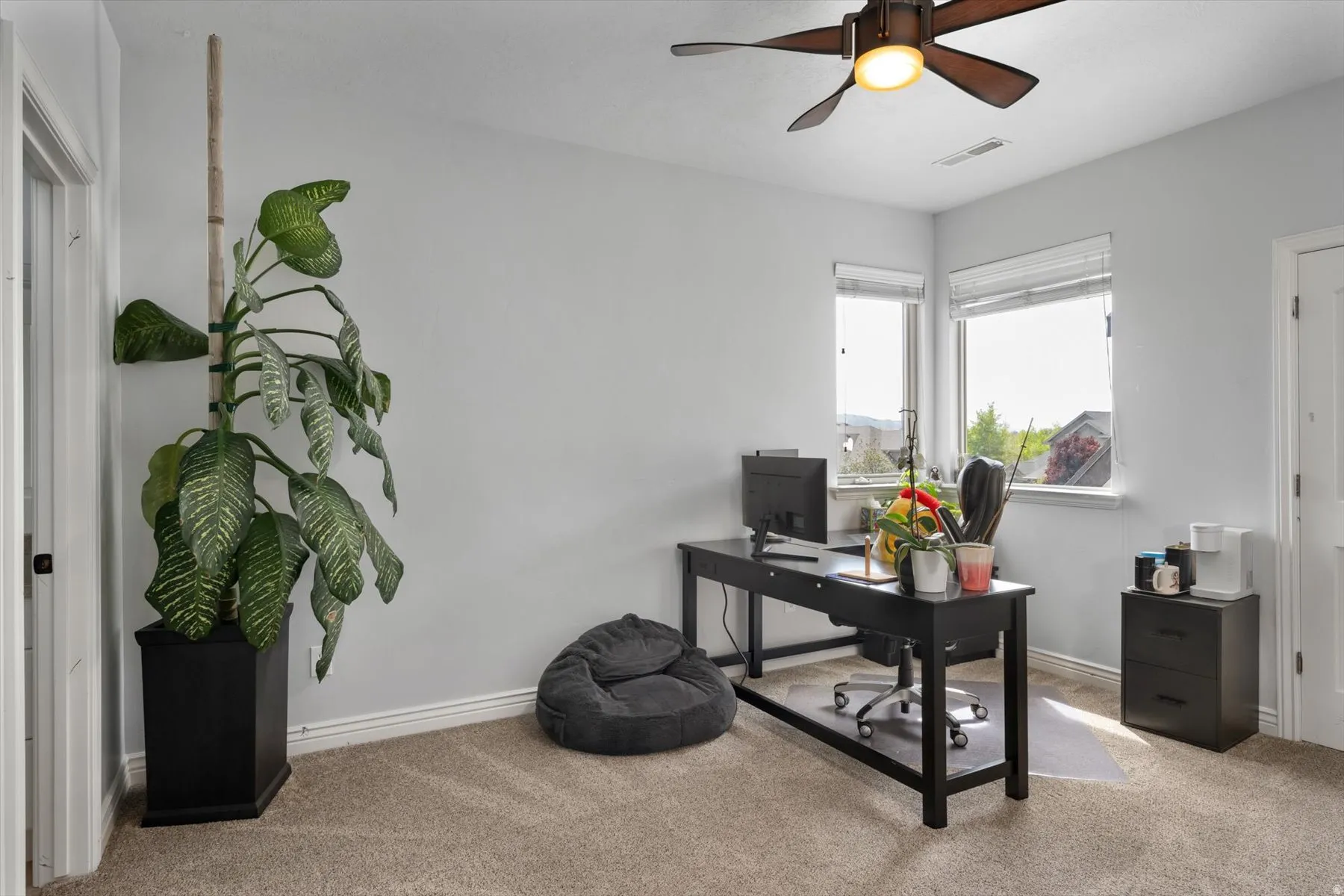 Carpeted bedroomroom with light gray walls, white trim, and a ceiling fan with light fixture