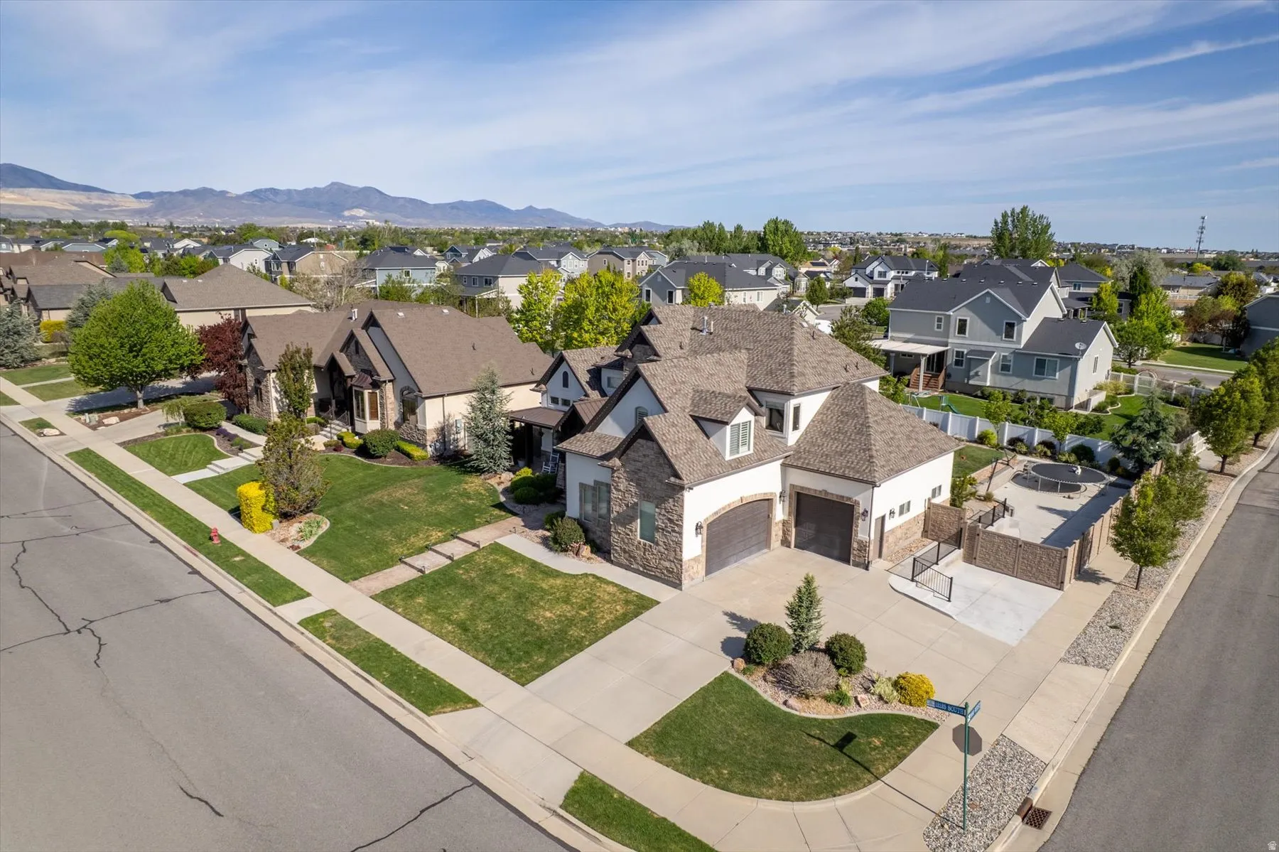 Two-story residence featuring a stone and stucco exterior, prominent gables, and an attached two-car garage