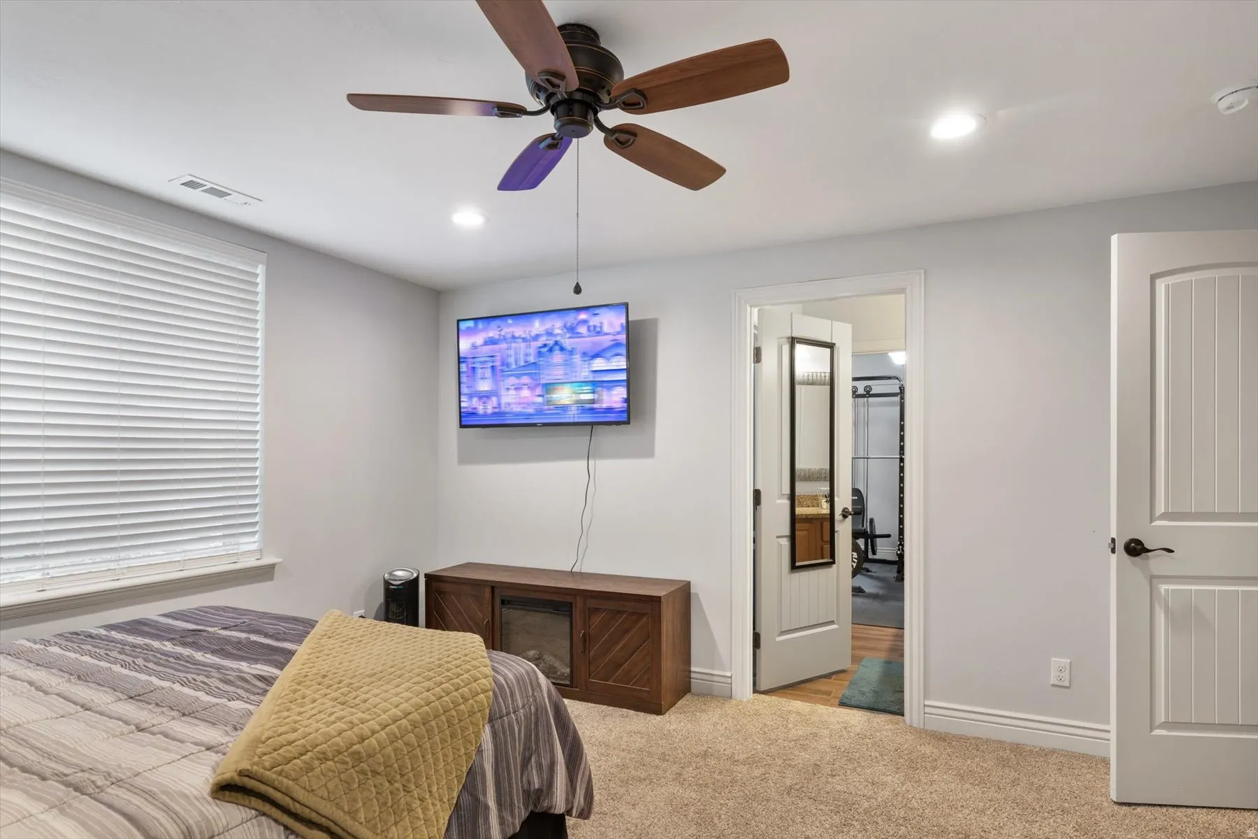 Carpeted bedroom featuring a ceiling fan with integrated lighting, recessed ceiling lights, a window with horizontal blinds, and baseboard molding