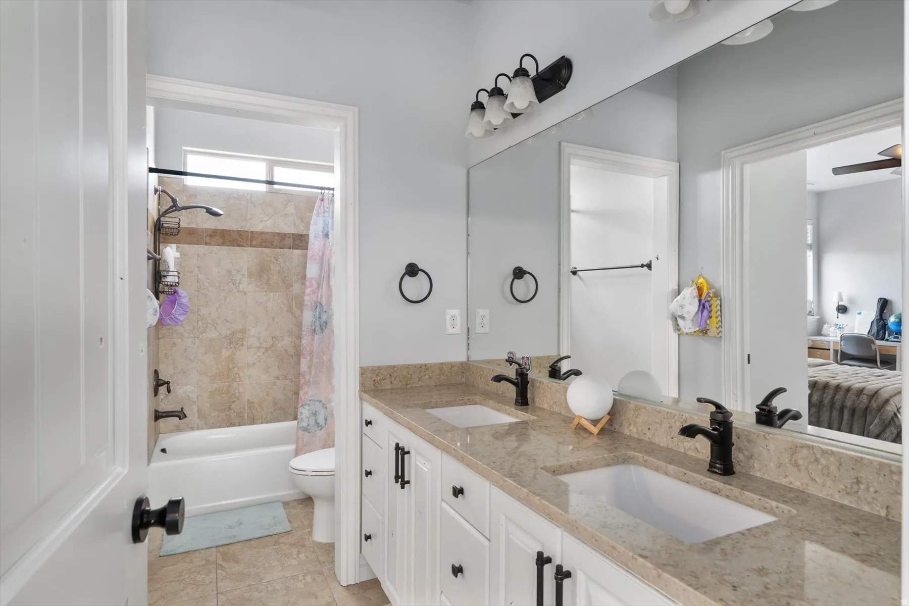 Full bathroom with dual vanity with integrated sinks, light-toned countertop, and matte black fixtures