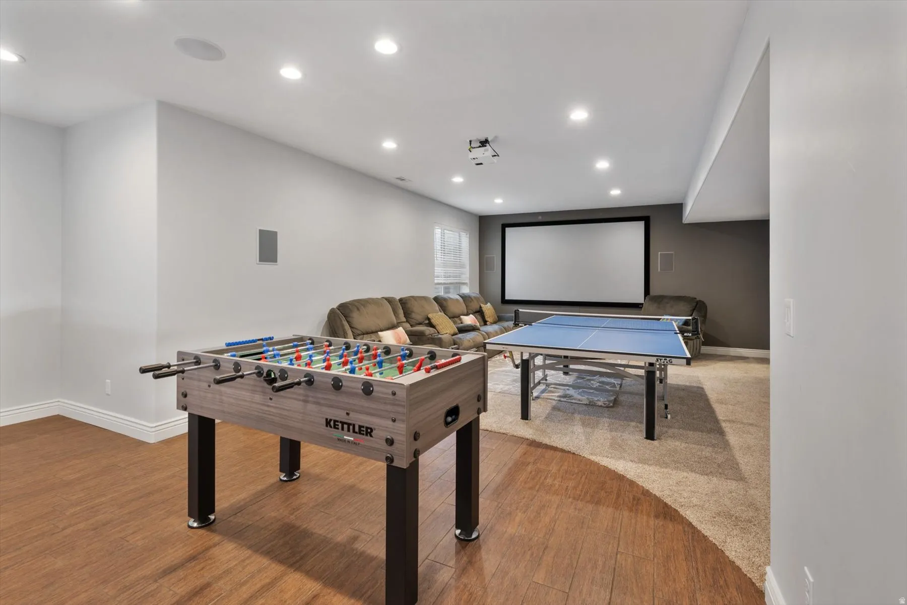 Entertainment area featuring a large projector screen, recessed lighting, and integrated ceiling speakers