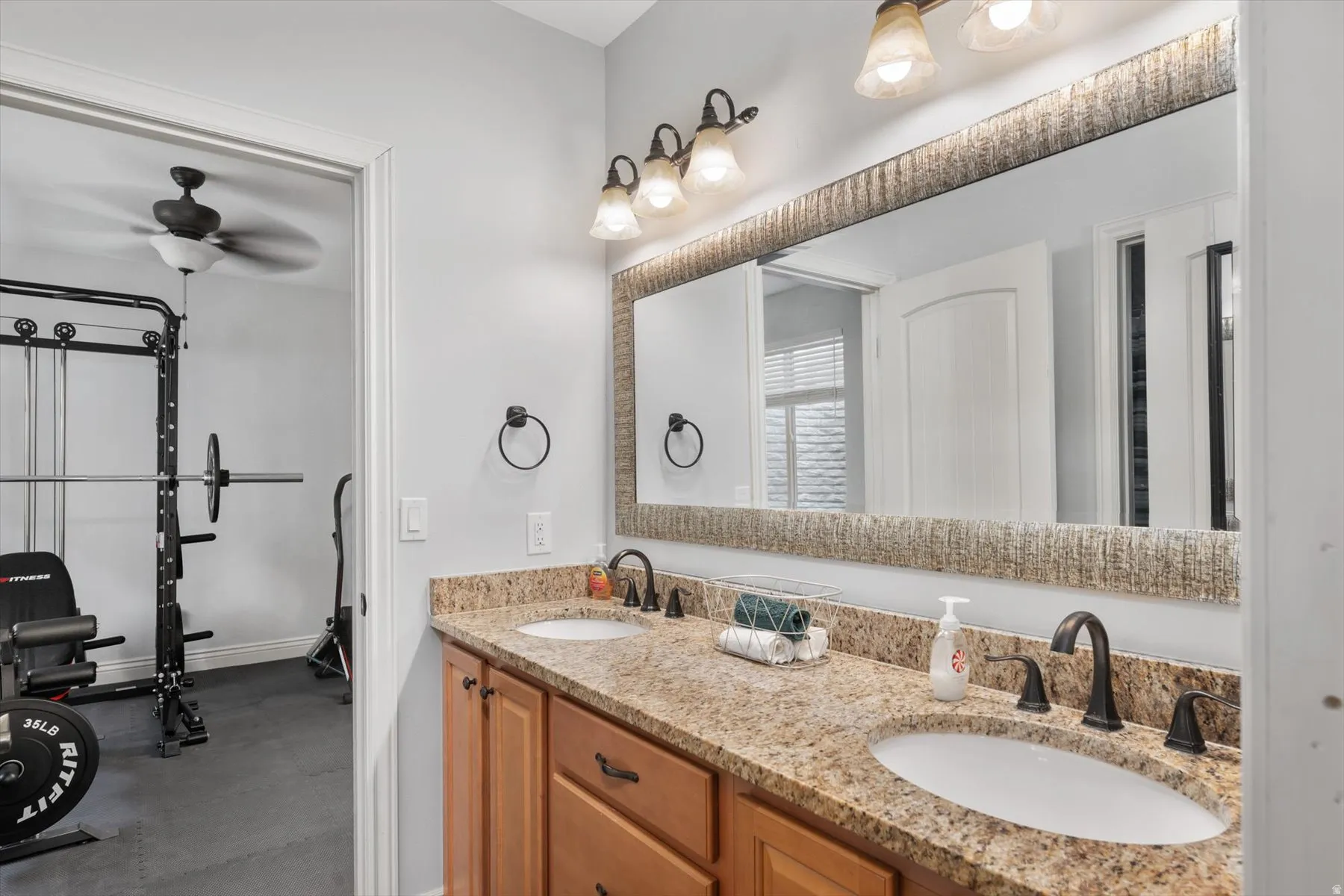 Full bathroom with dual vanity with granite-style countertop, undermount sinks, and oil-rubbed bronze fixtures